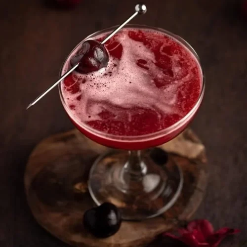 Bourbon Cherry cocktail served in a glass with cherries and bourbon garnish