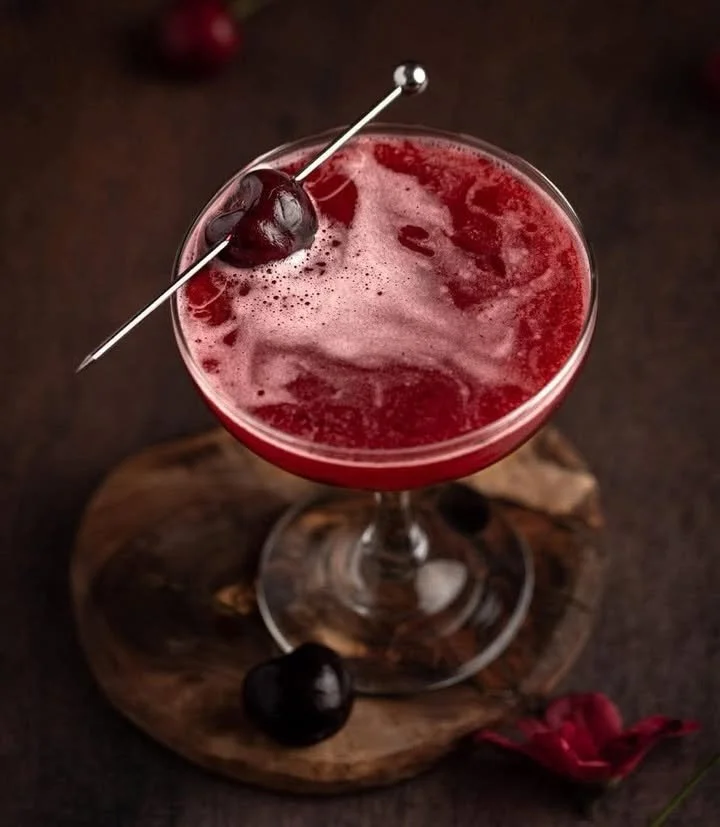 Bourbon Cherry cocktail served in a glass with cherries and bourbon garnish