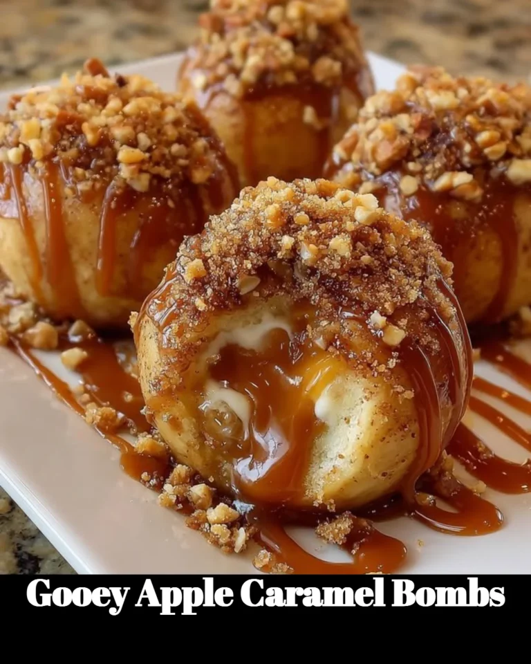 Gooey apple caramel bombs drizzled with caramel sauce on a white plate.