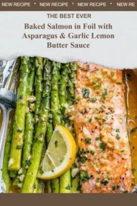 Baked salmon in foil served with asparagus and garlic lemon butter sauce.