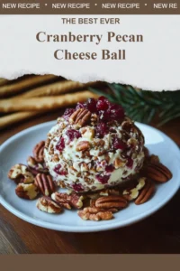 Cranberry Pecan Cheese Ball garnished with nuts and herbs on a serving platter